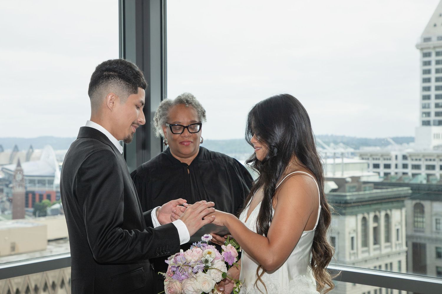 Couple exchanging wedding rings during an intimate Seattle Municipal Court ceremony