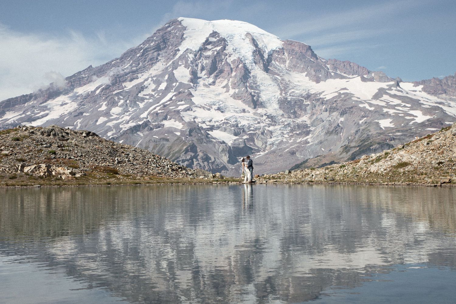 Snow-covered Mount Rainier reflected in the still water of an alpine lake during an intimate elopement