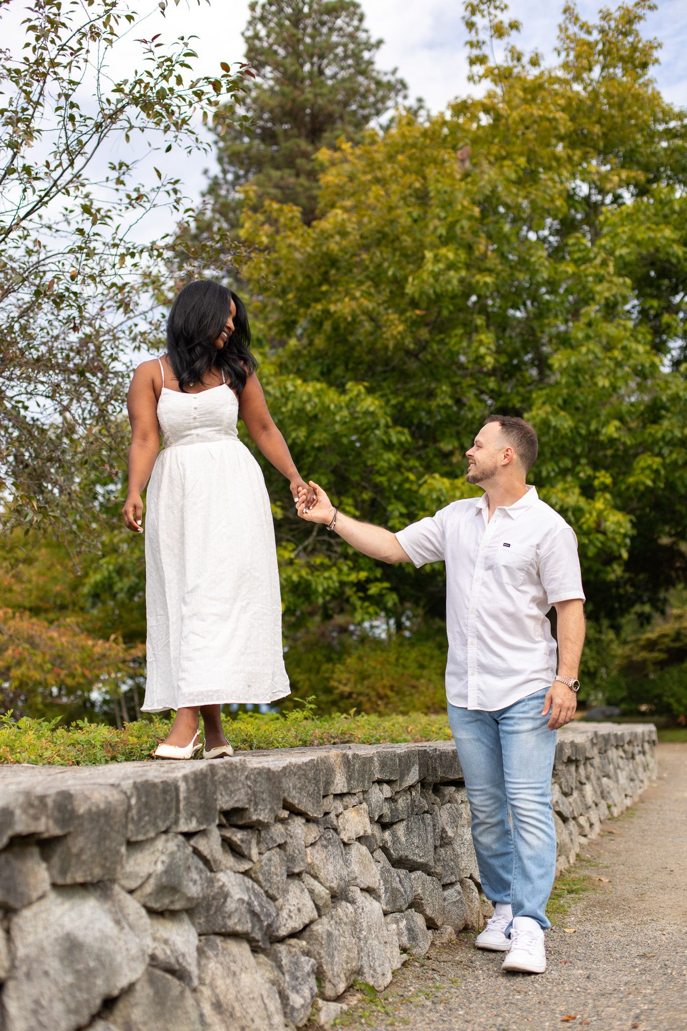 Candid engagement photos at Discovery Park, couple laughing and holding hands during their session