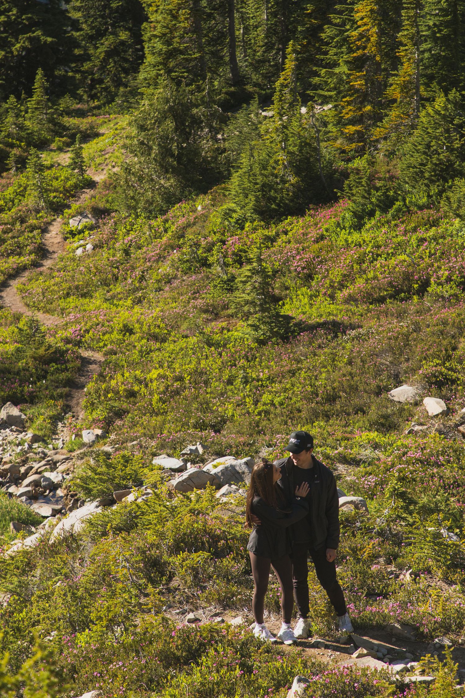 Couple embracing on a mountain trail during their Mount Rainier proposal photoshoot