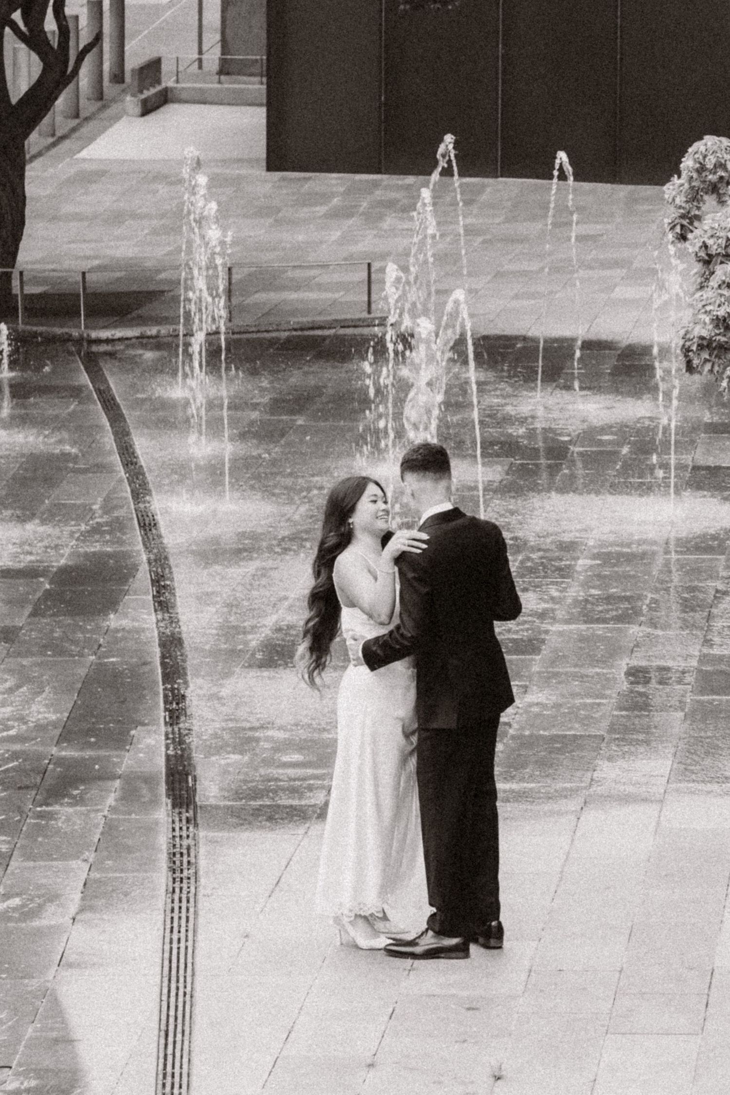 Black and white portrait of newlyweds beside downtown fountains after their Seattle Municipal Court ceremony
