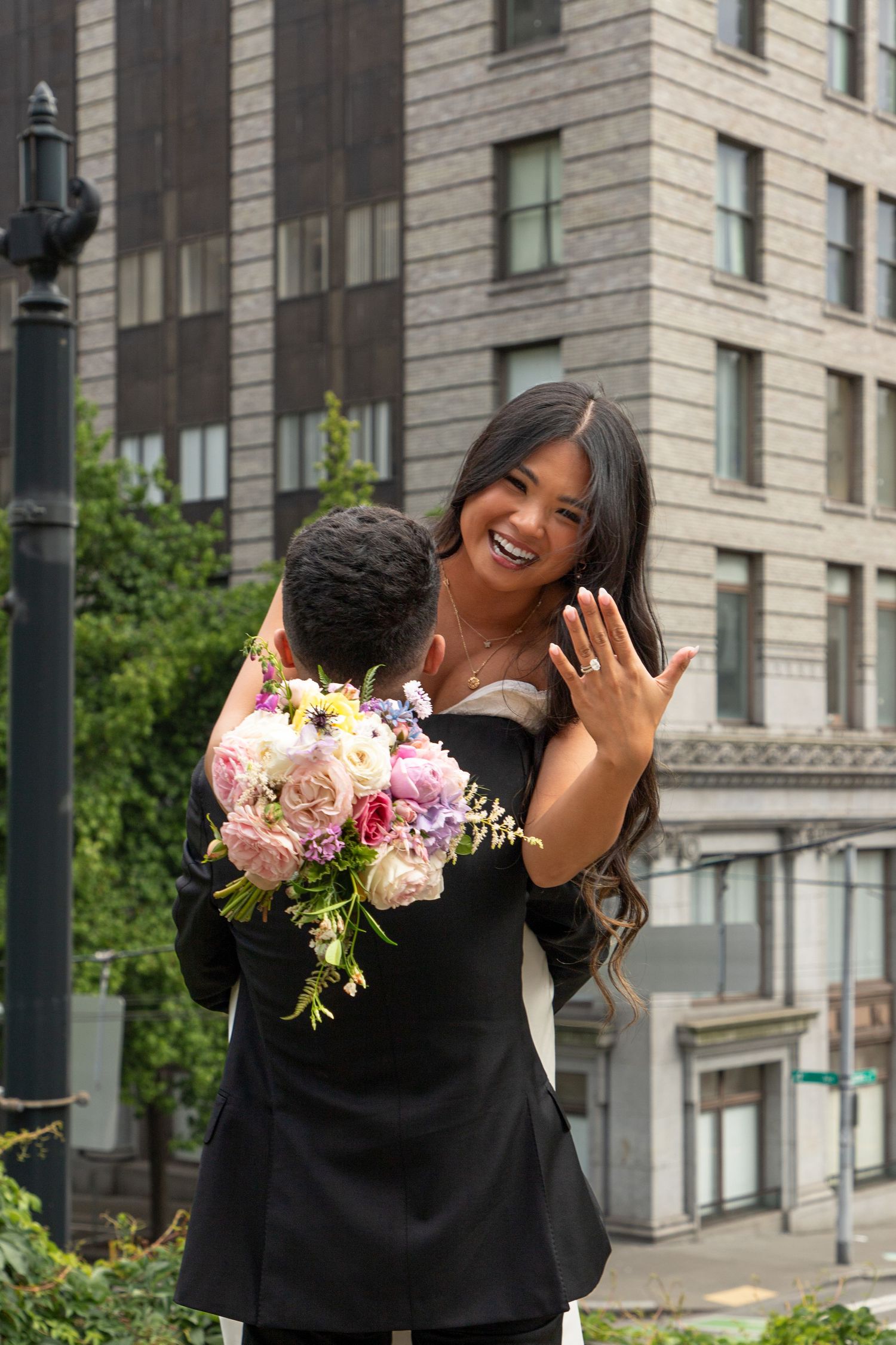 Bride showing her wedding ring while holding a colorful bouquet after a Seattle Municipal Court wedding