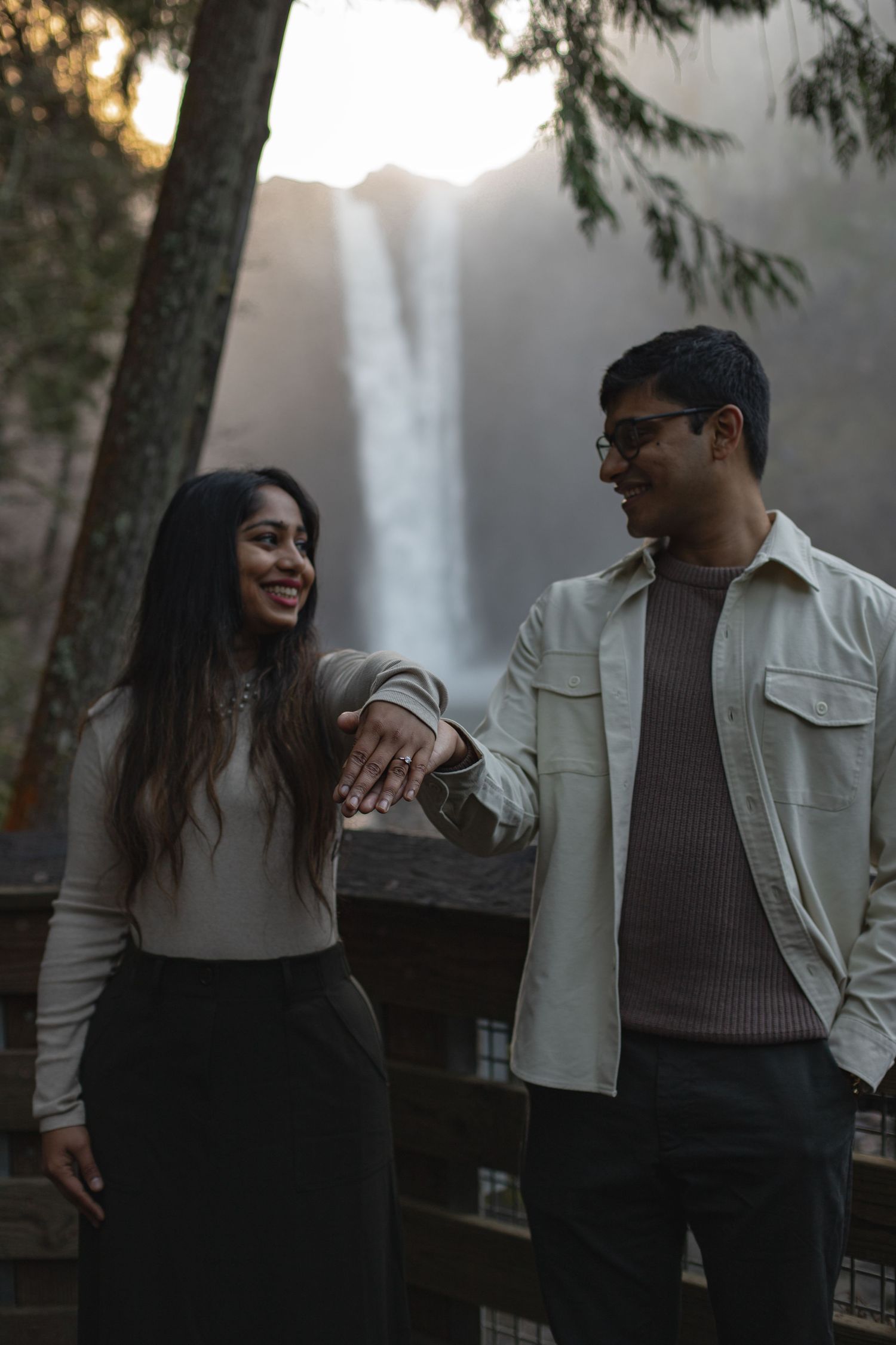 Engagement photoshoot at Snoqualmie Falls near Seattle, couple standing with the waterfall in the background