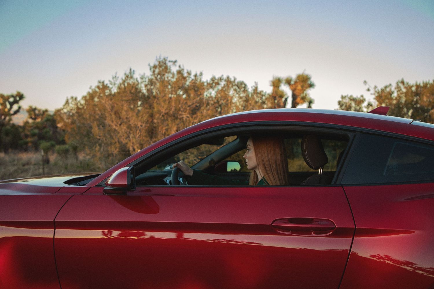Seattle portrait photographer capturing a woman’s portrait photoshoot of a girl driving a red car