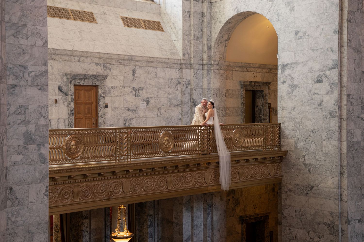 Bride standing on the upper balcony inside the Washington State Capitol building during an elegant Olympia elopement session