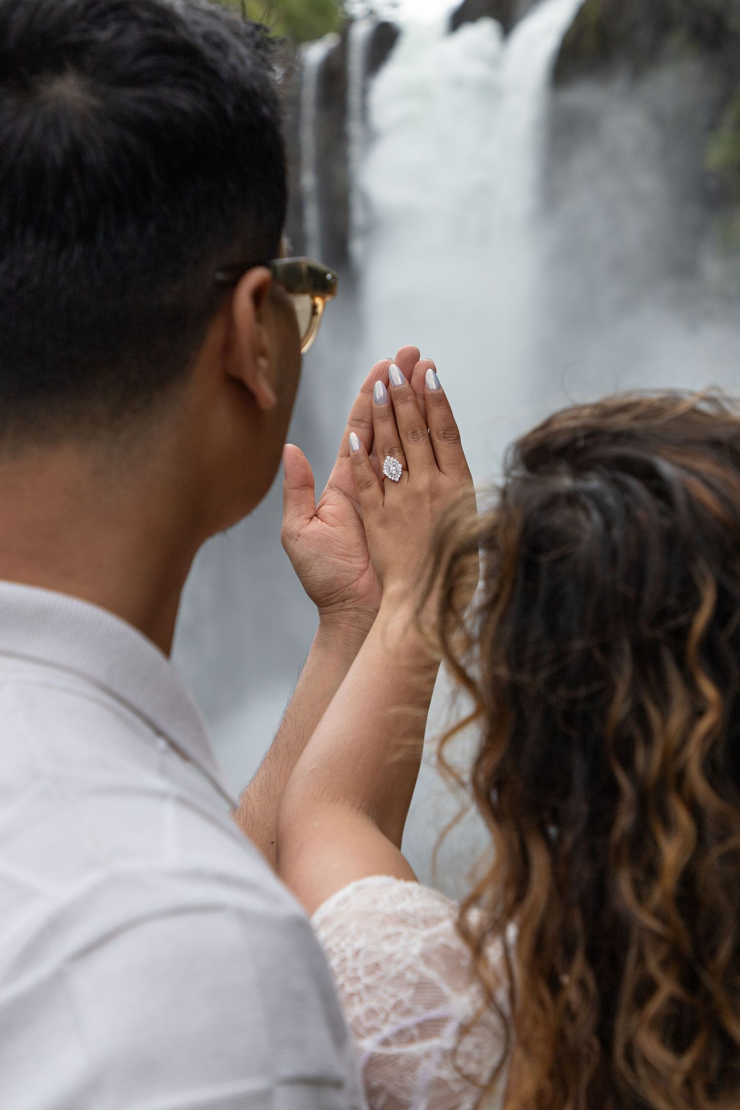 Woman showing her engagement ring with Snoqualmie Falls in the background