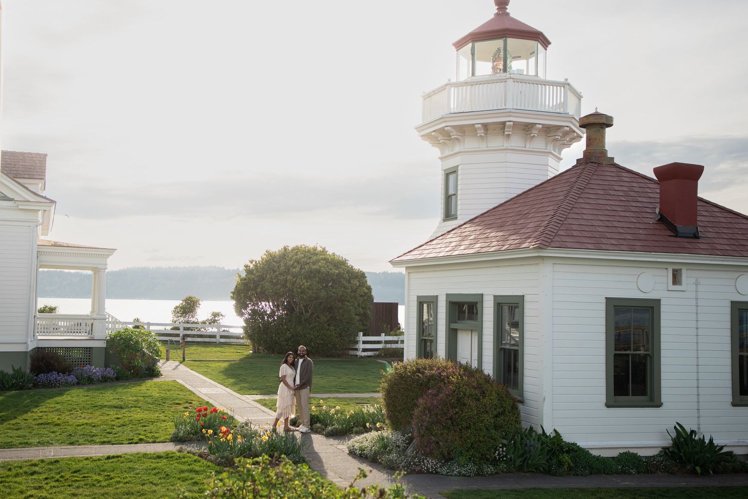 Newly engaged couple walking through the gardens at Mukilteo Lighthouse Park
