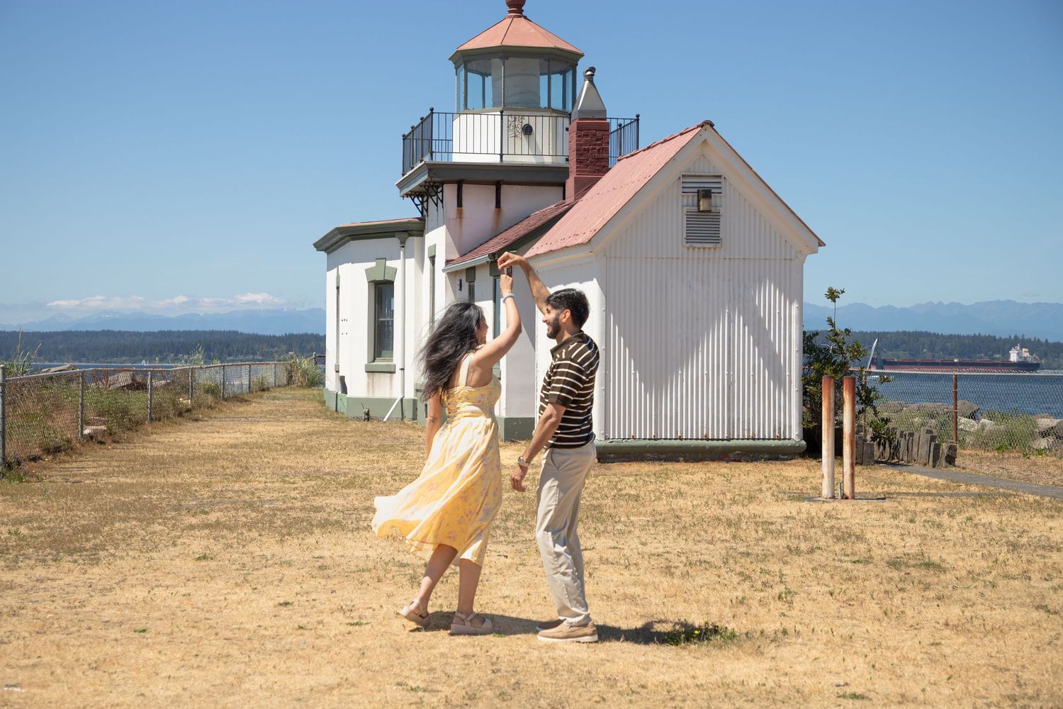 Couple dancing beside West Point Lighthouse after a surprise proposal at Discovery Park
