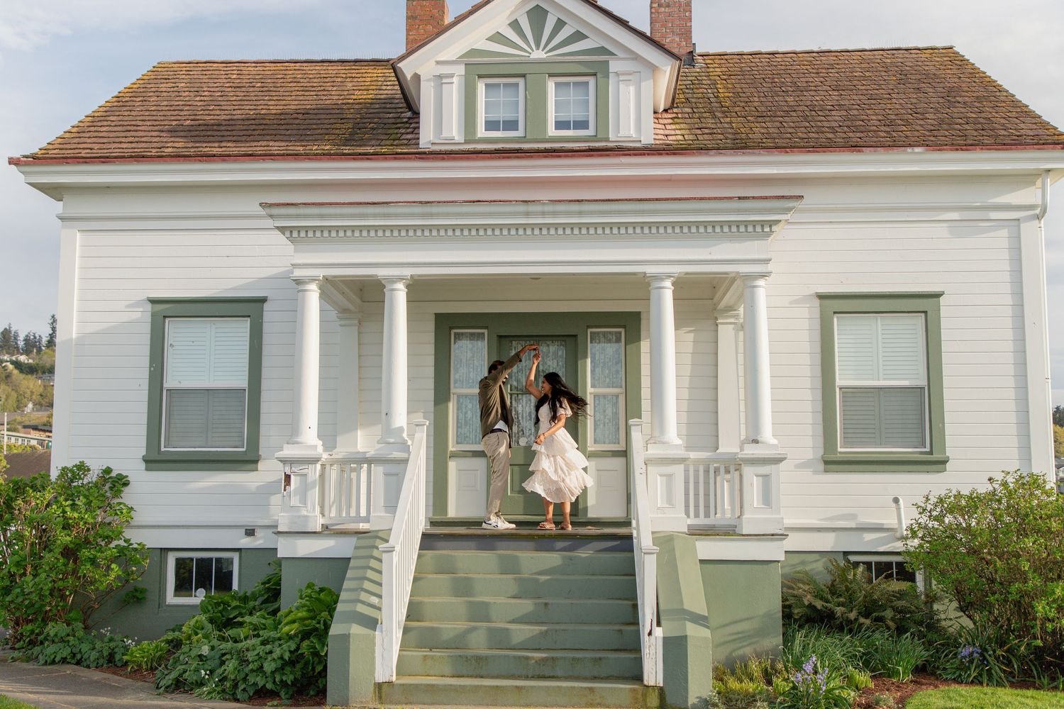 Newly engaged couple walking down the steps of the historic light station at Mukilteo Lighthouse Park