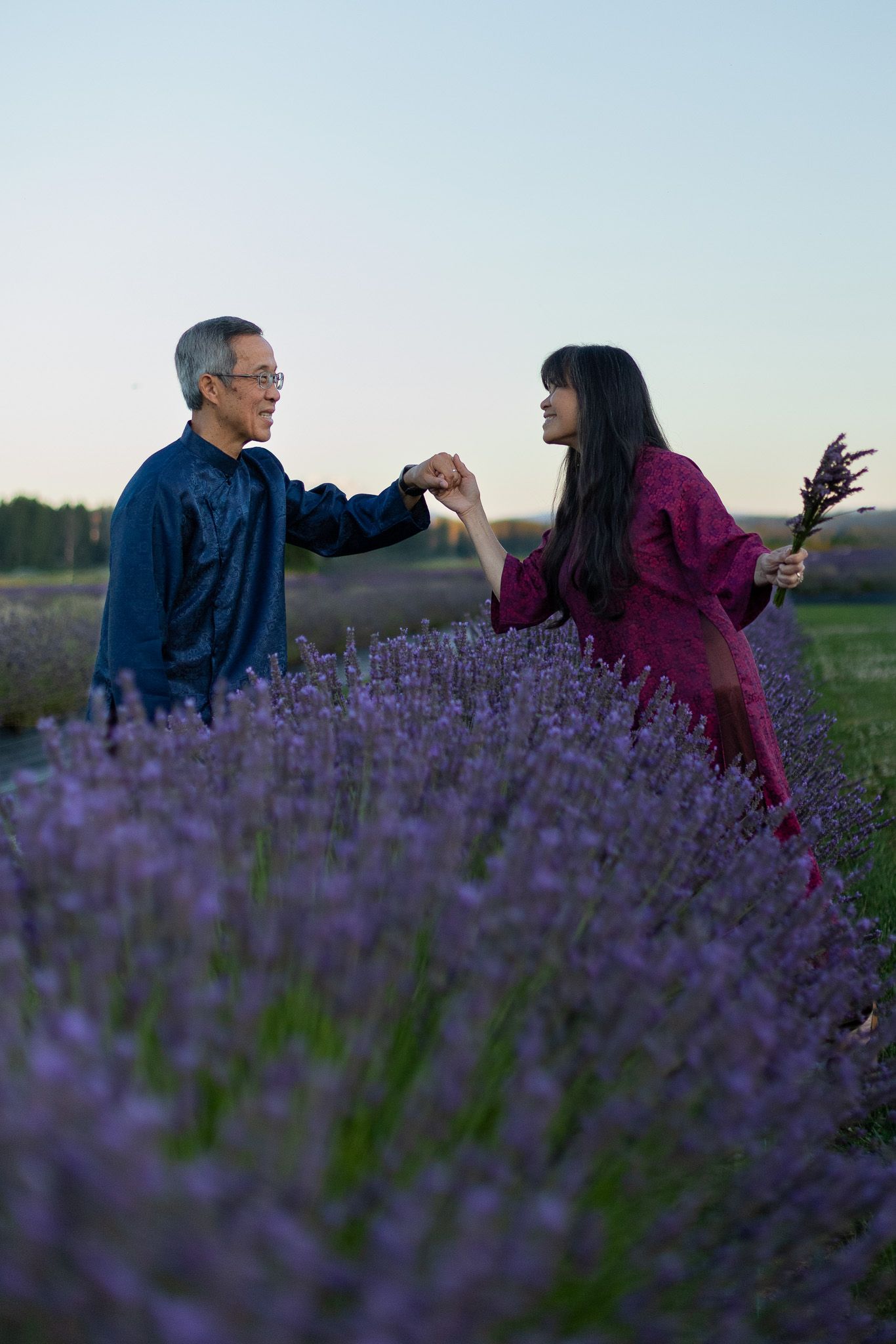 Seattle anniversary photographer documenting a couple walking through blooming lavender fields in Woodinville