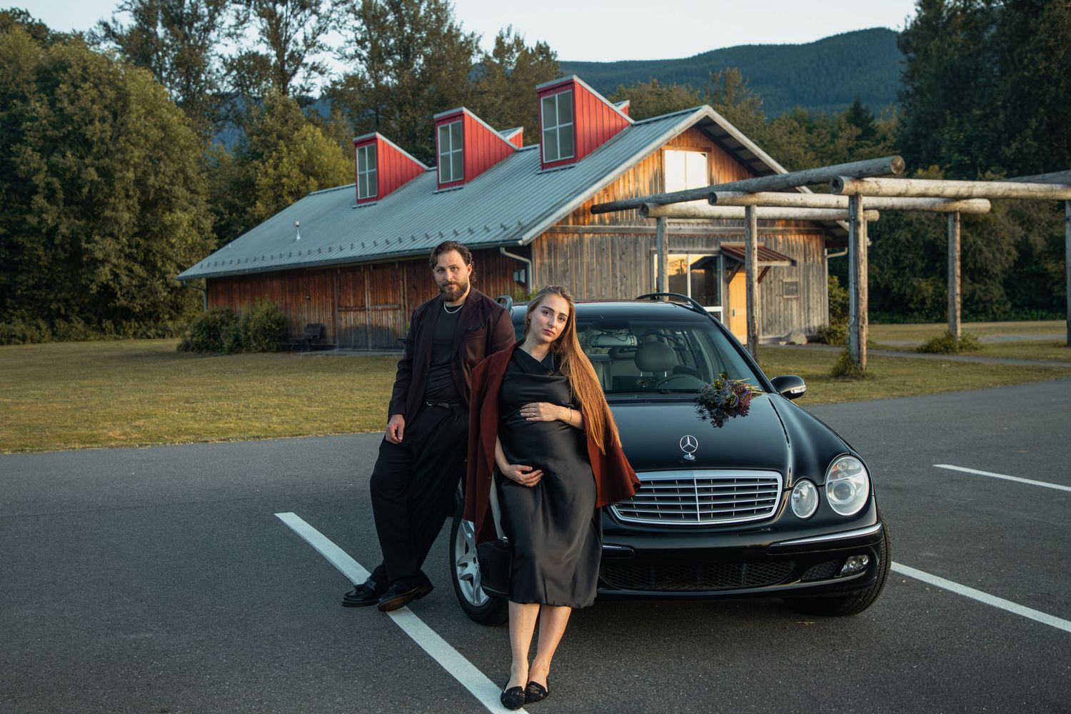 Pregnant woman and her partner walking past a vintage car during their North Bend maternity session