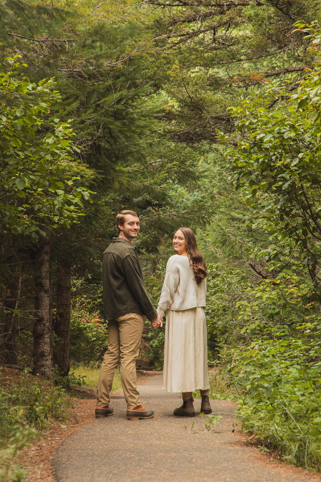 Candid couple photos at Gold Creek Pond, partners walking along the path during their photoshoot