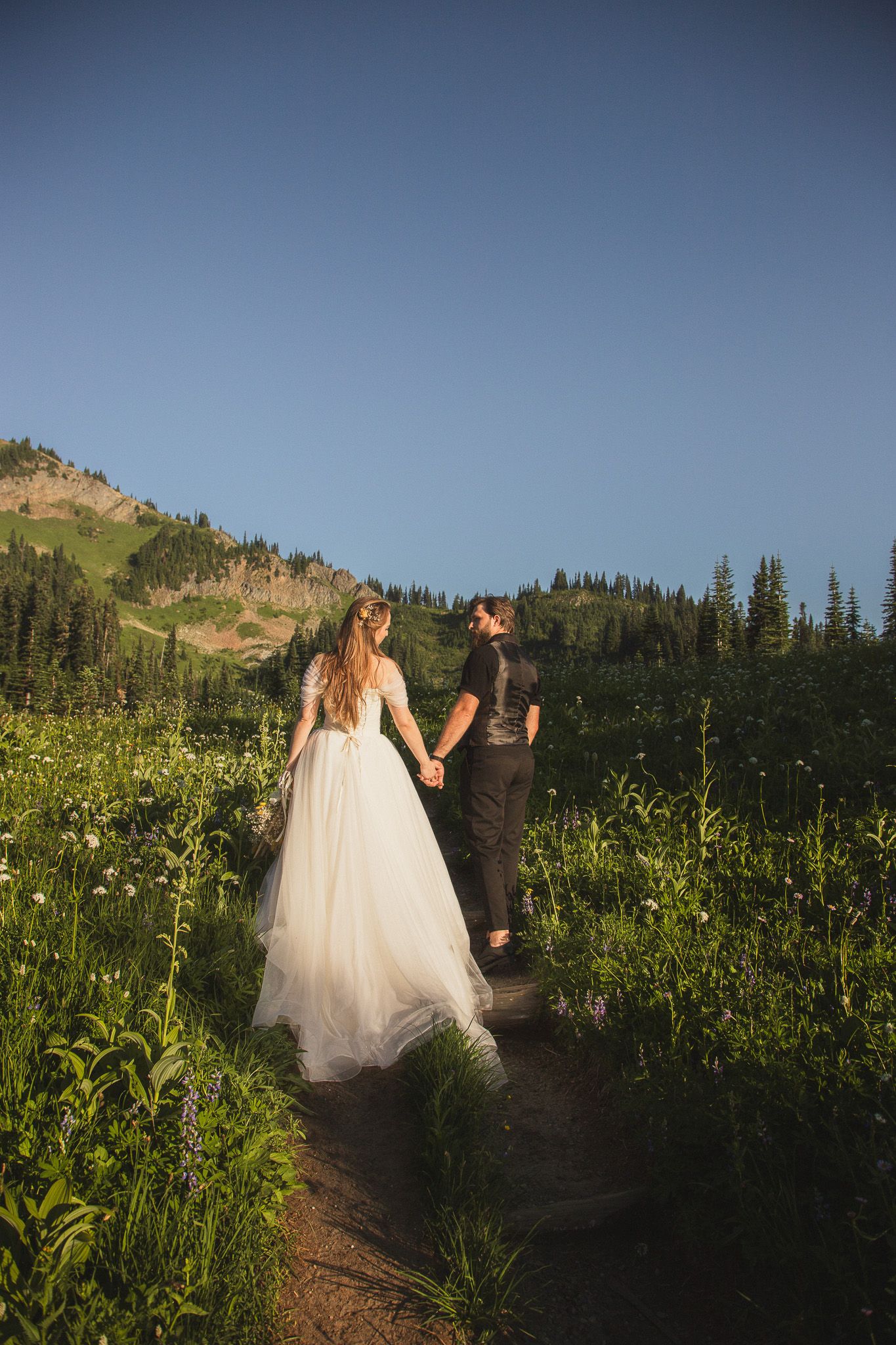 Candid elopement photoshoot at Tipsoo Lake, couple walking along the trail at golden hour