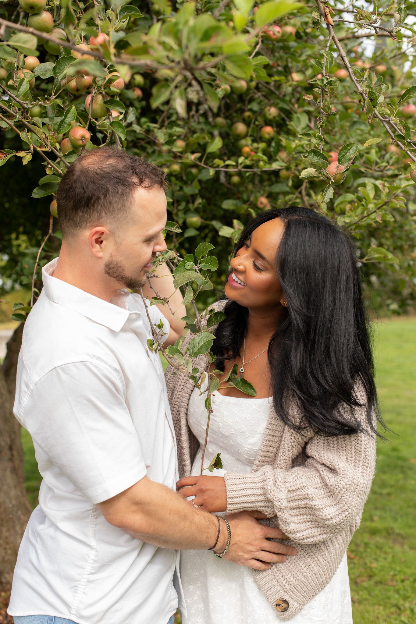 Candid engagement photos at Discovery Park, couple laughing and holding hands during their session