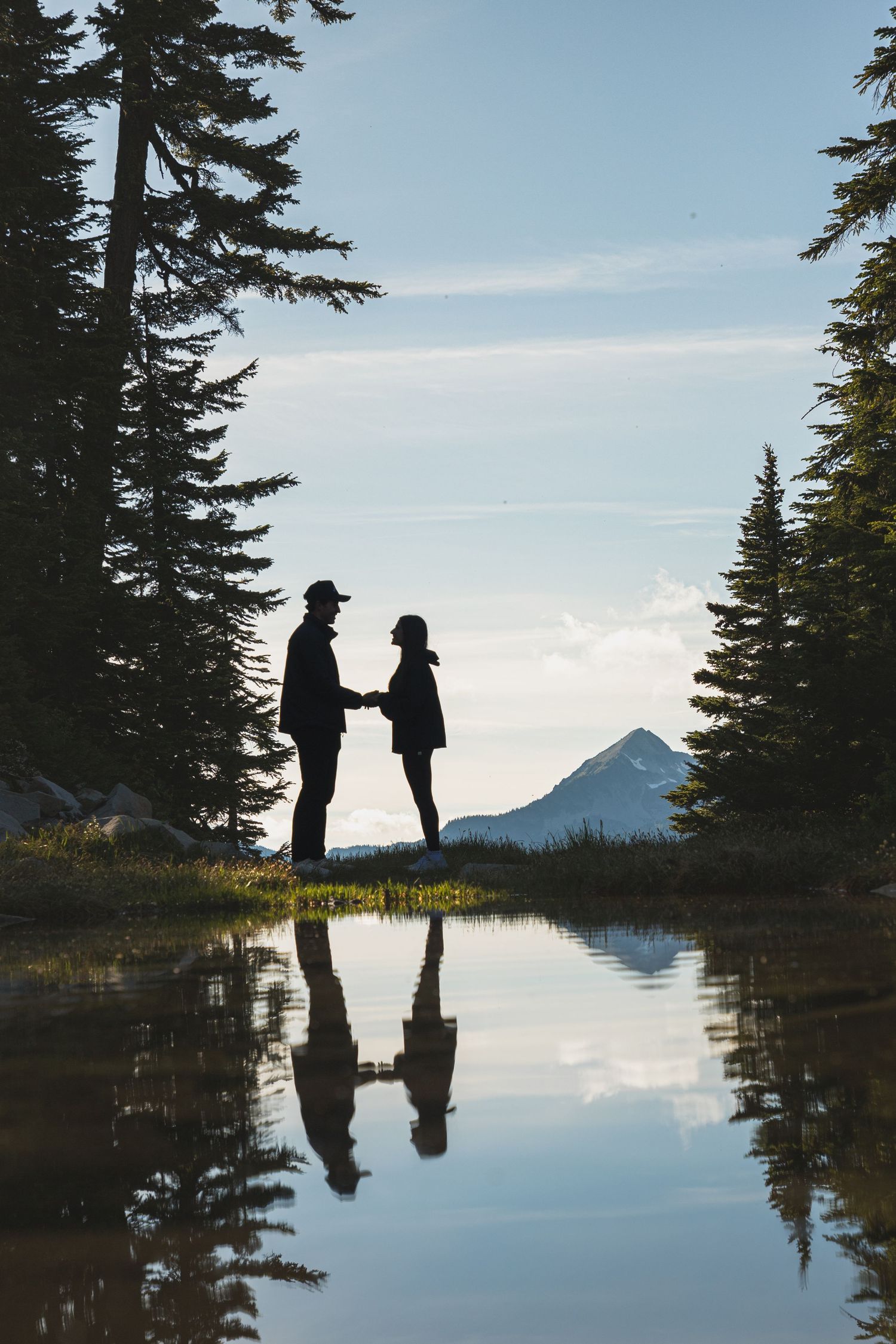 Couple reflected in an alpine pond during a romantic Mount Rainier engagement session