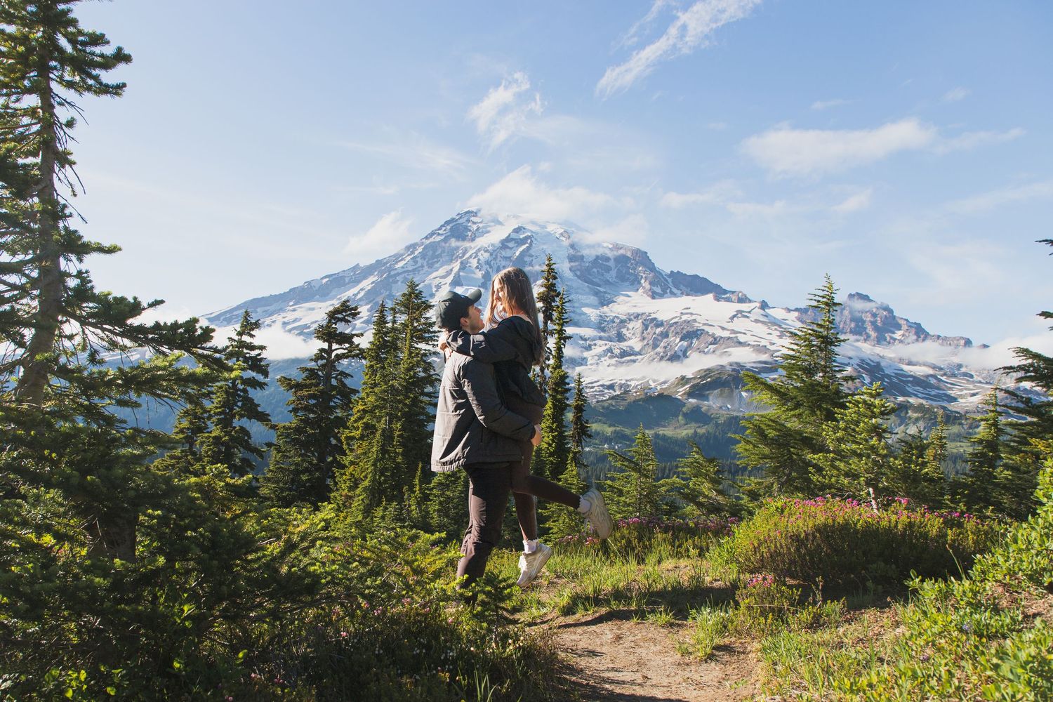 Playful couple portrait with Mount Rainier in the background after a surprise proposal