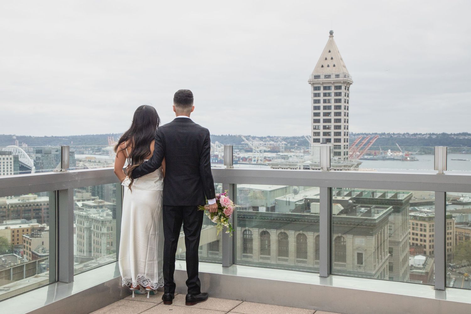 Bride and groom overlooking downtown Seattle from the Municipal Court rooftop