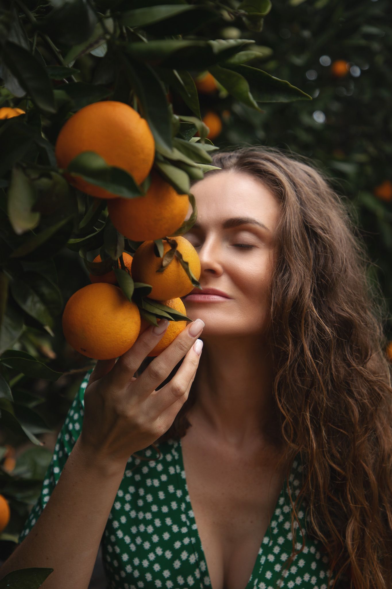 Seattle portrait photographer photographing a woman in blooming orange blossoms during a spring photoshoot
