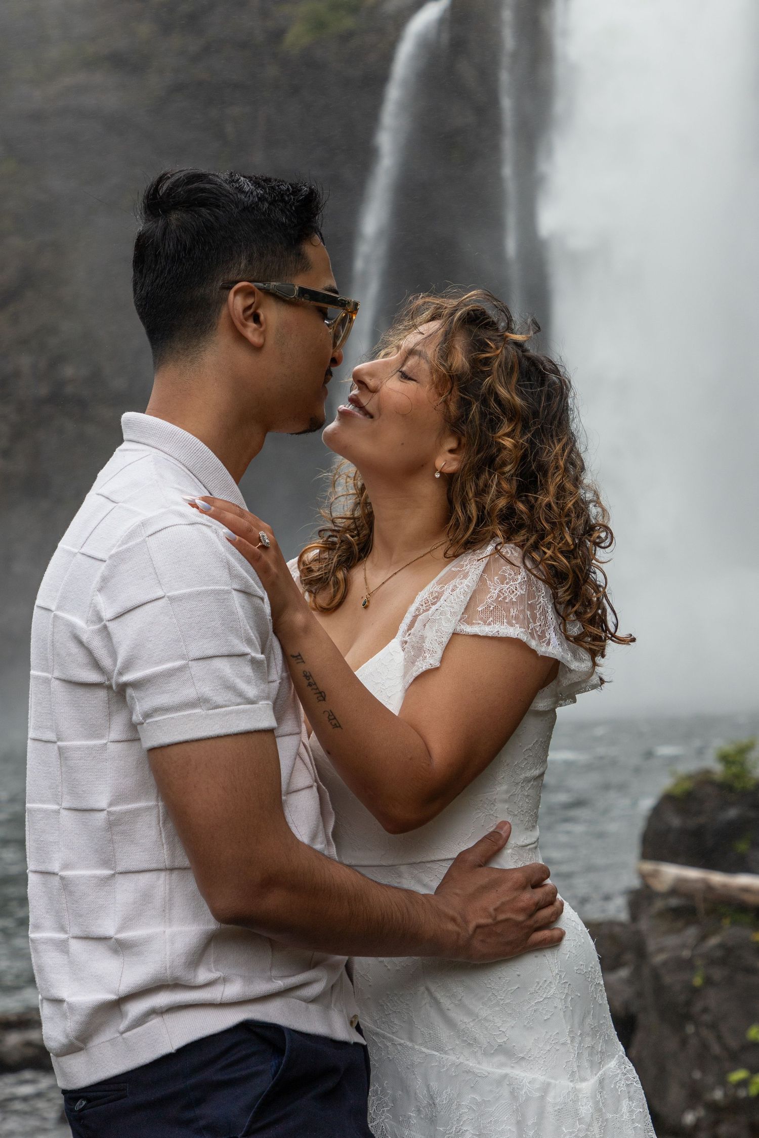 Romantic close-up of a newly engaged couple embracing beside Snoqualmie Falls