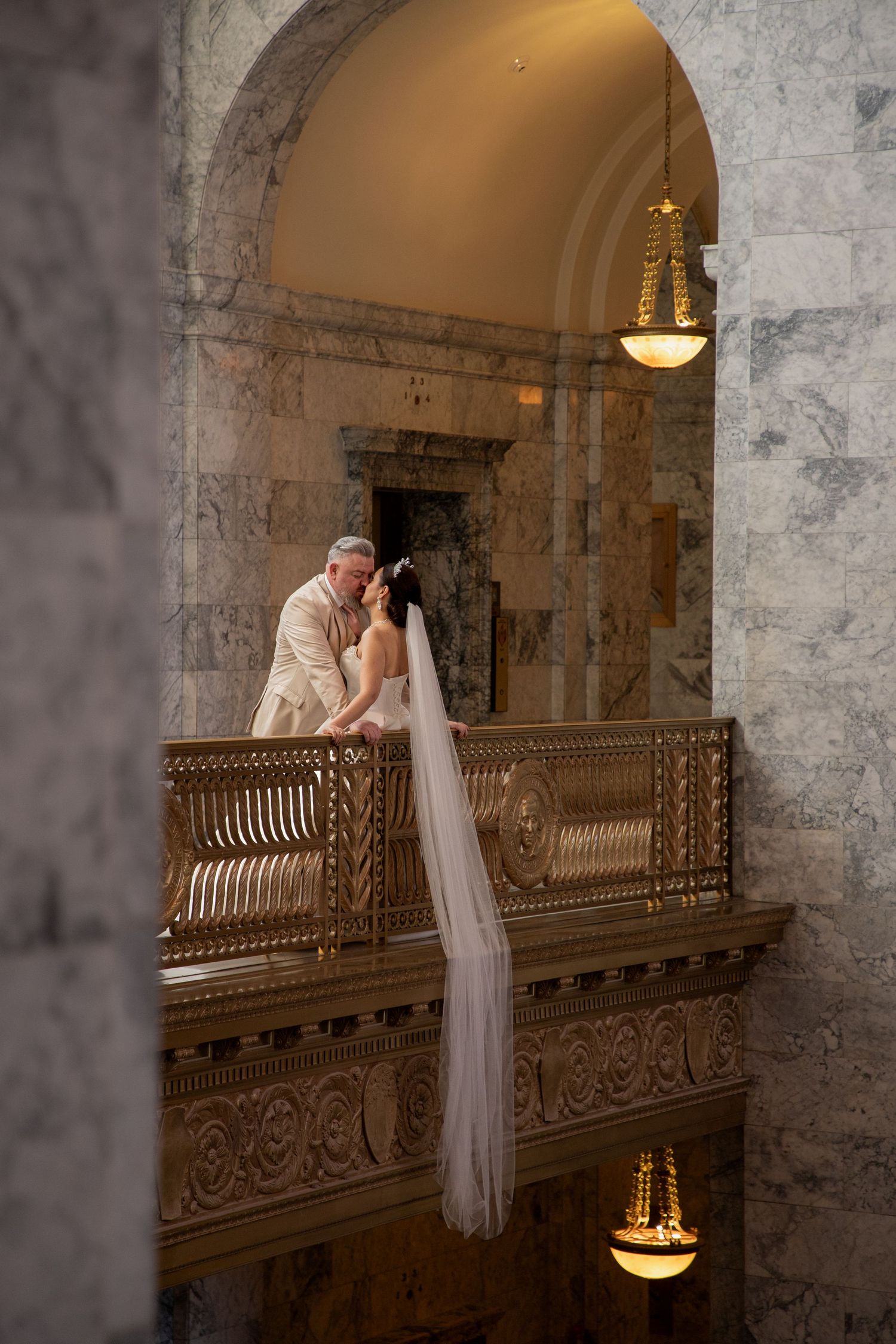 Bride and groom sharing a quiet moment beneath a grand chandelier inside the Washington State Capitol in Olympia