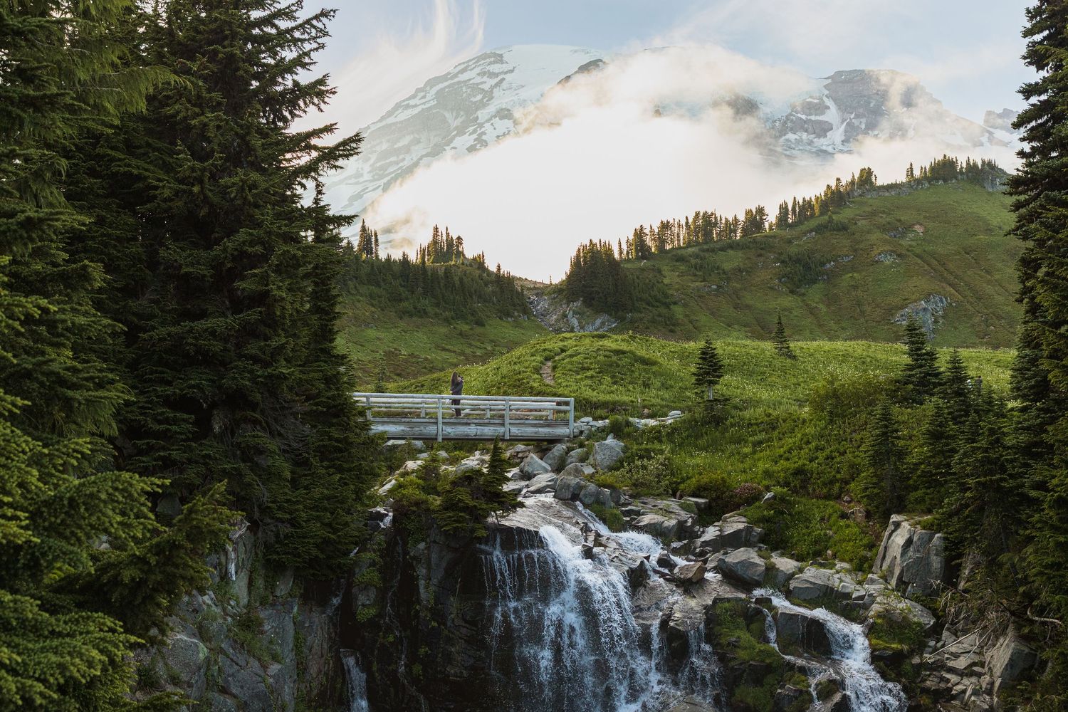Couple standing on the bridge above Myrtle Falls in the Paradise area of Mount Rainier National Park