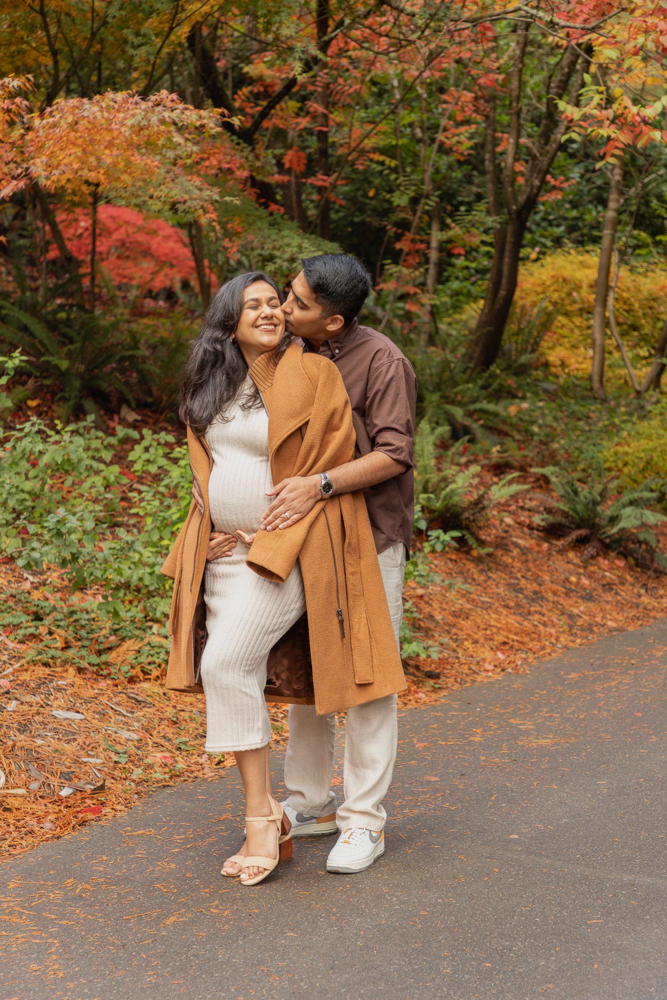 Seattle maternity photographer photographing a joyful pregnant couple laughing together in the gardens at Washington Park Arboretum