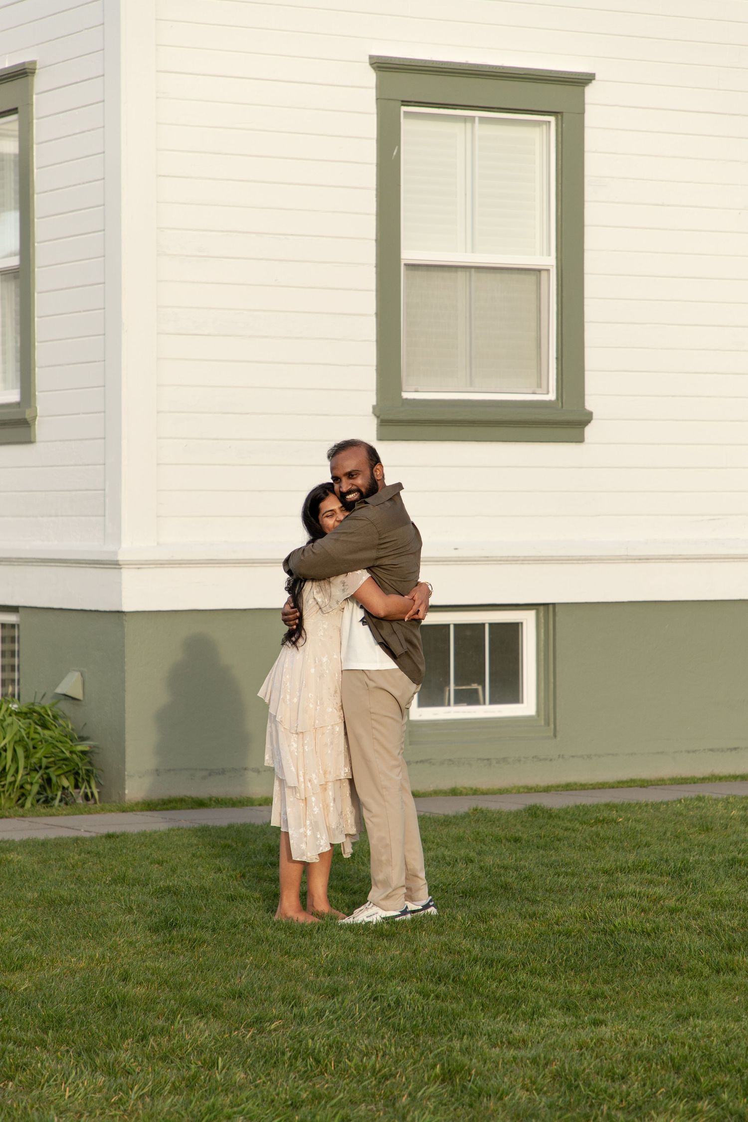 Newly engaged couple hugging outside the light station during their Mukilteo proposal session