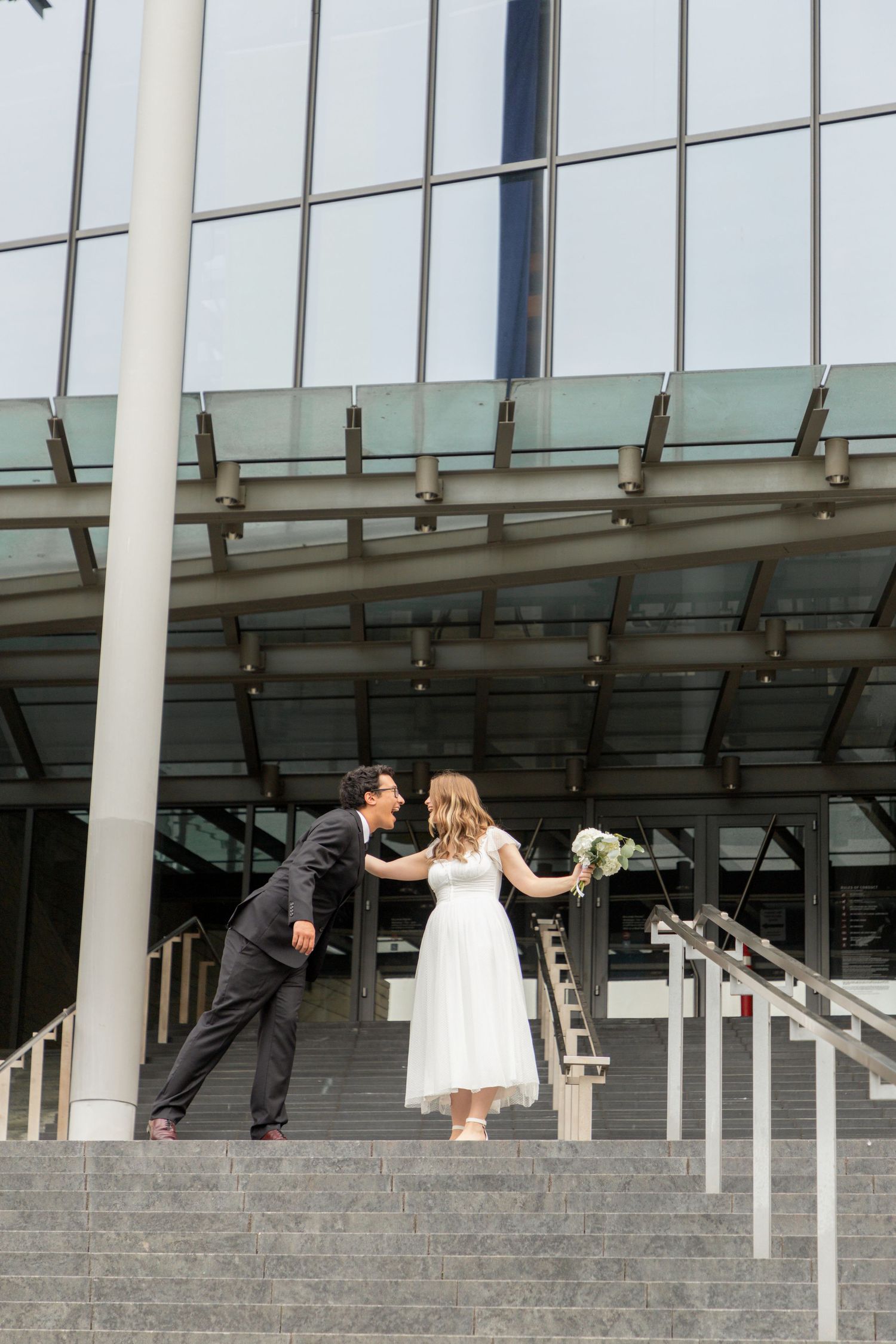 Newlywed couple kissing on the steps outside Seattle Municipal Court