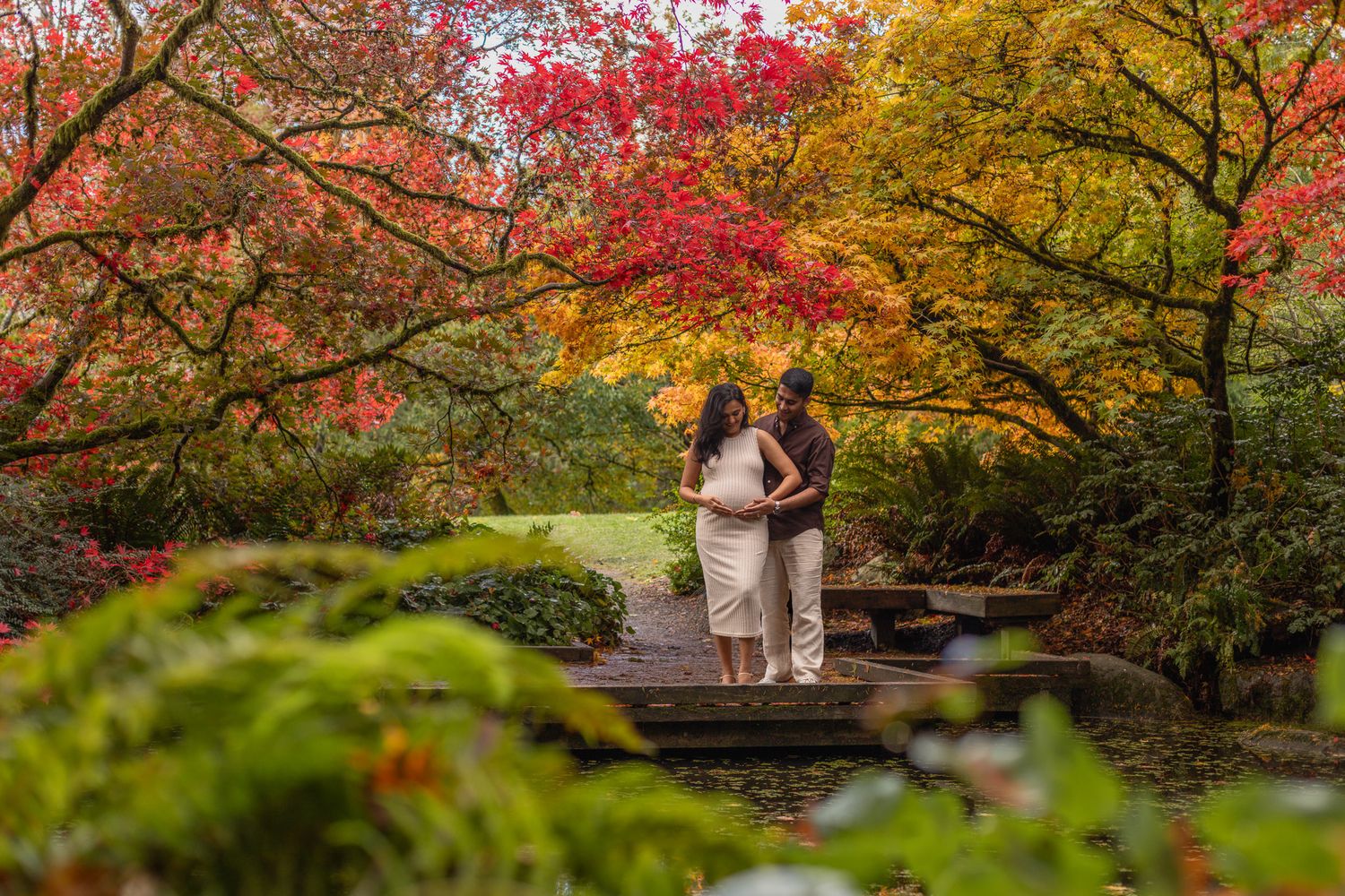 Seattle maternity photographer documenting tender moments between a pregnant woman and her partner at Washington Park Arboretum