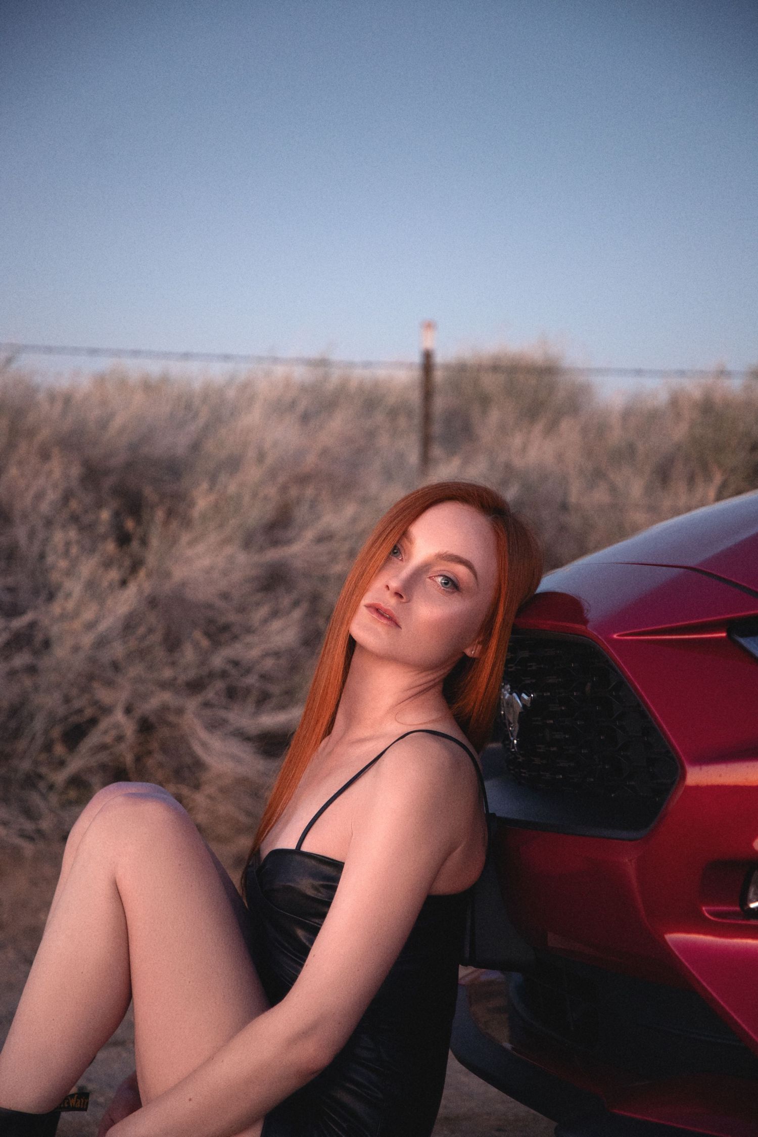 California desert portrait of a woman with a red car during a creative photoshoot