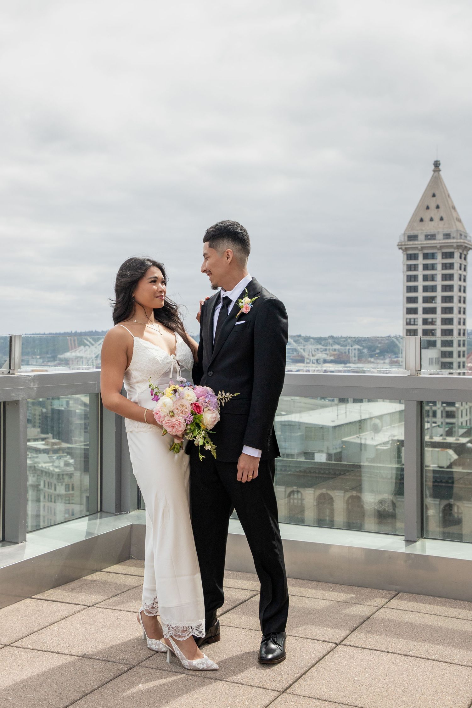 Newlywed couple posing on the Seattle Municipal Court rooftop with the downtown skyline