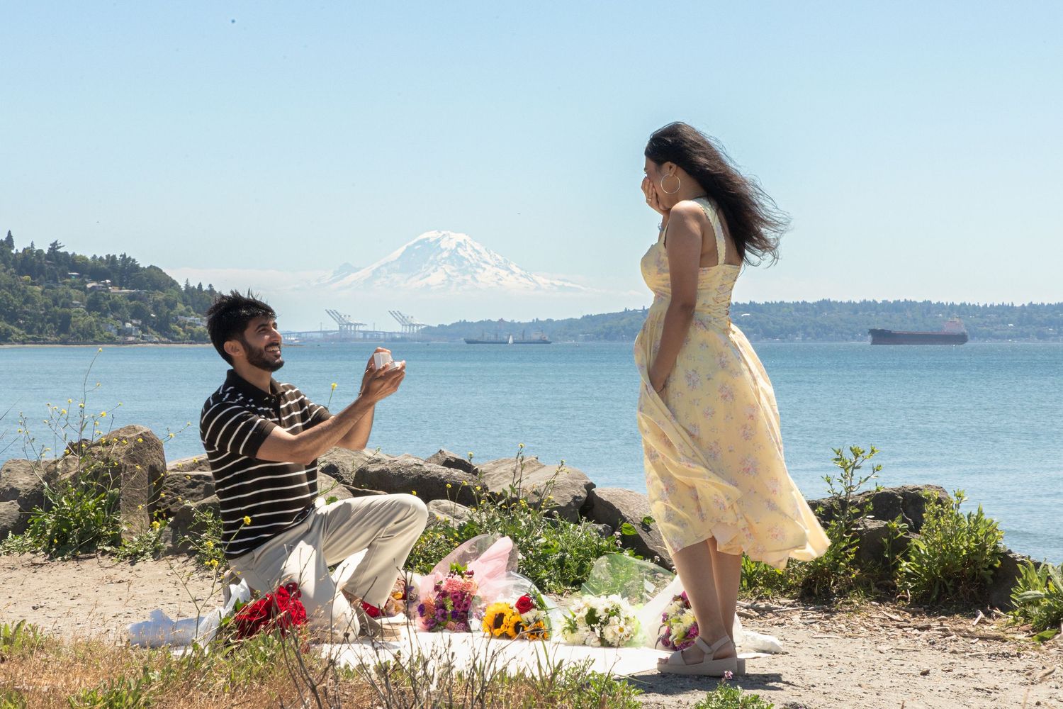 Surprise marriage proposal by the water at Discovery Park with Mount Rainier in the background