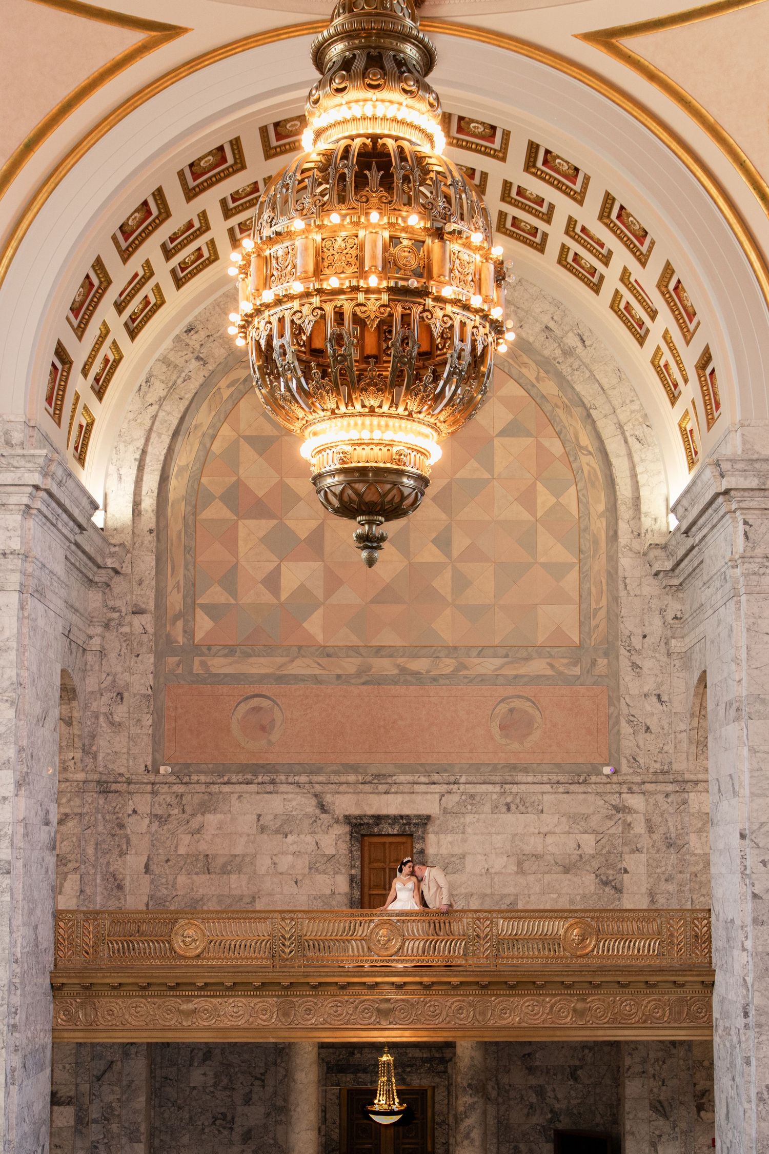 Bride standing on the upper balcony inside the Washington State Capitol building during an elegant Olympia elopement session