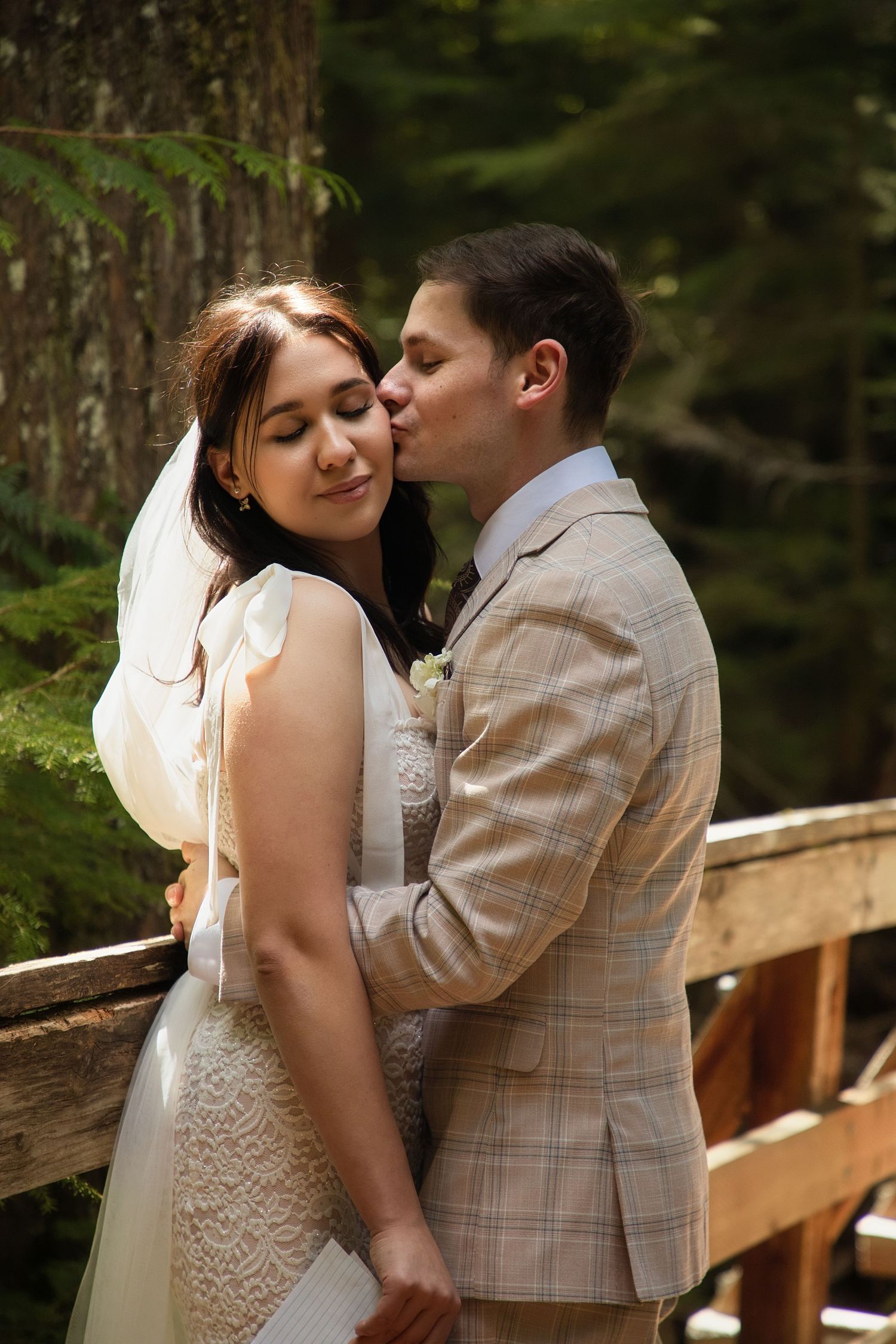 Bride and groom sharing a quiet moment on a forest bridge during their Washington elopement day