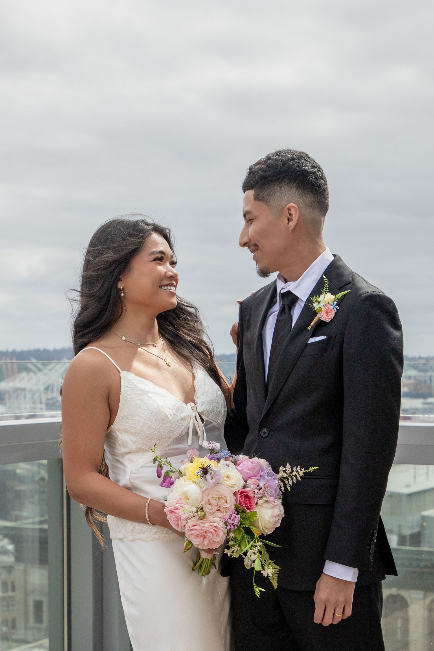Bride and groom posing with a colorful bouquet on the Seattle Municipal Court rooftop