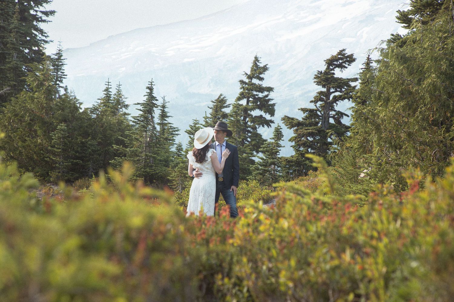 Bride and groom embracing in an alpine meadow during their Mount Rainier elopement