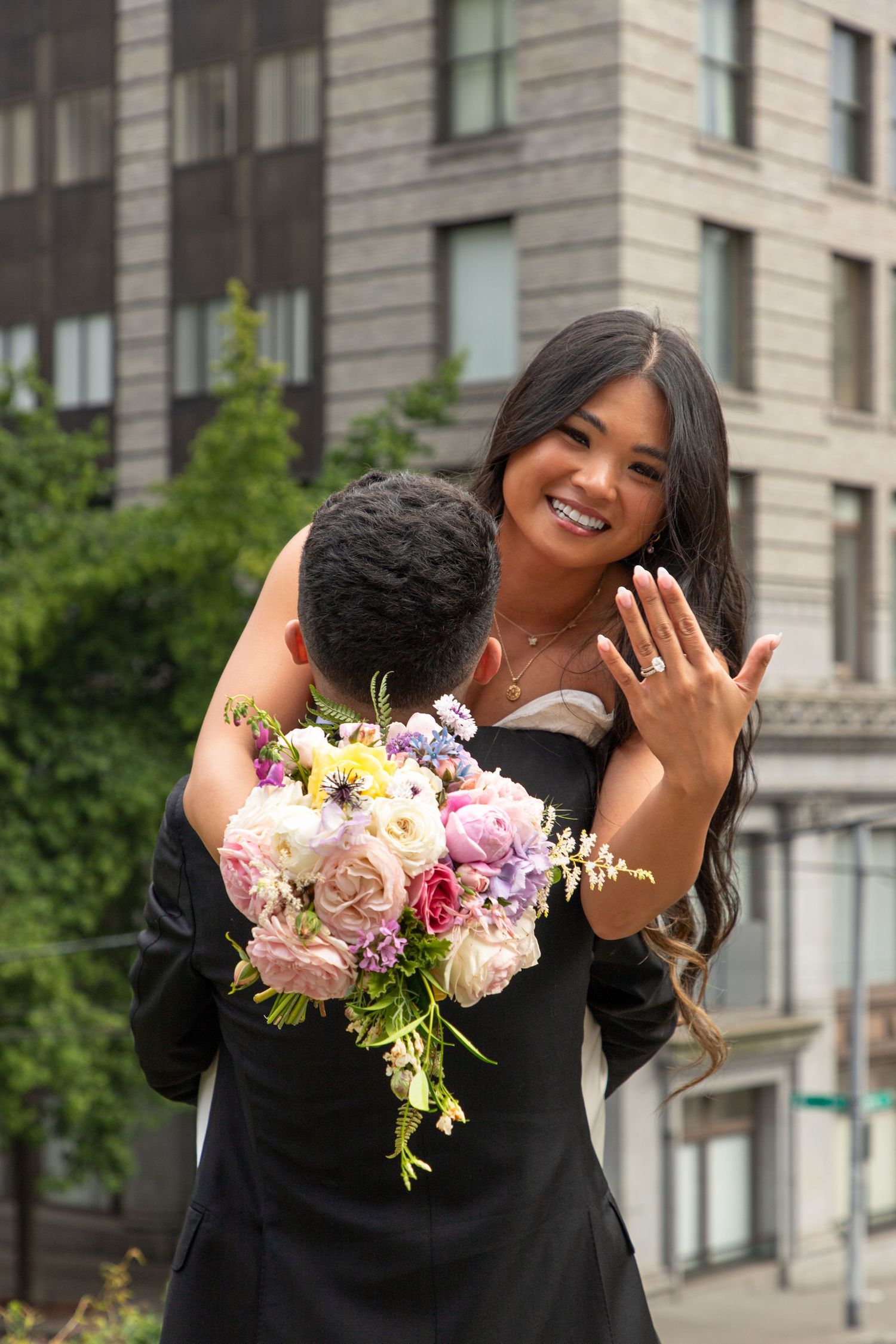 Bride showing her wedding ring while holding a colorful bouquet after a Seattle Municipal Court wedding