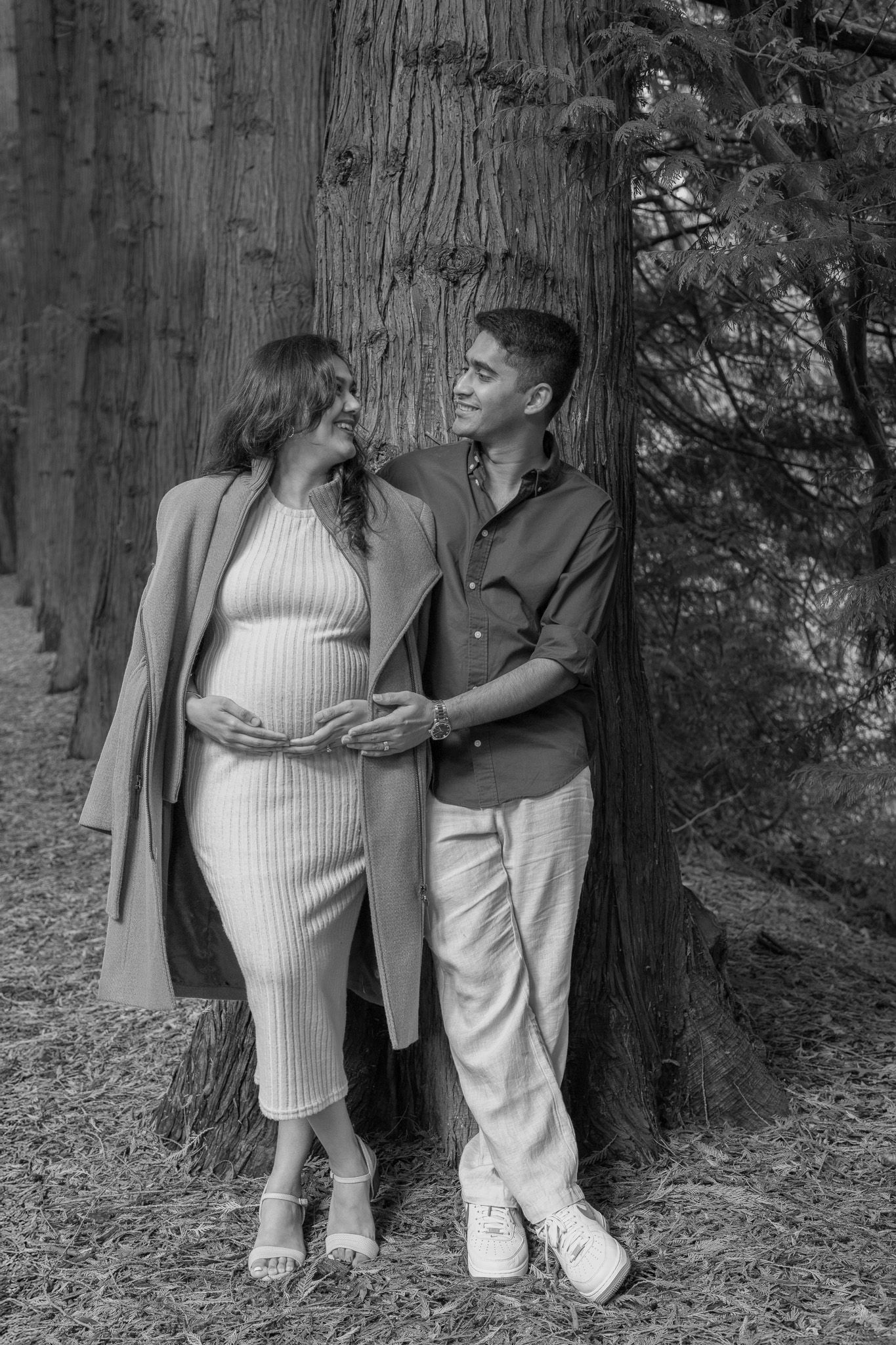 Seattle maternity photographer capturing a pregnant couple cuddling during a sunset photoshoot at Washington Park Arboretum