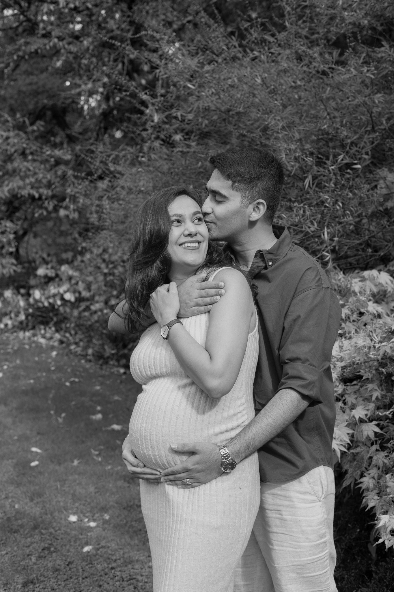 Pregnant couple embracing among greenery during a Washington Park Arboretum maternity photoshoot with a Seattle photographer