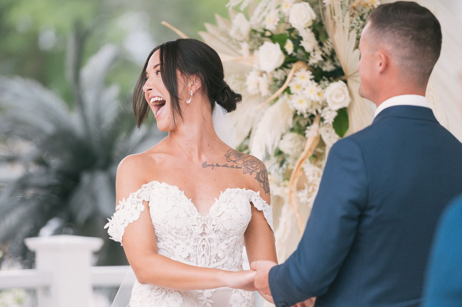 A romantic wedding moment captured in soft lighting with white floral arrangements and elegant decor.