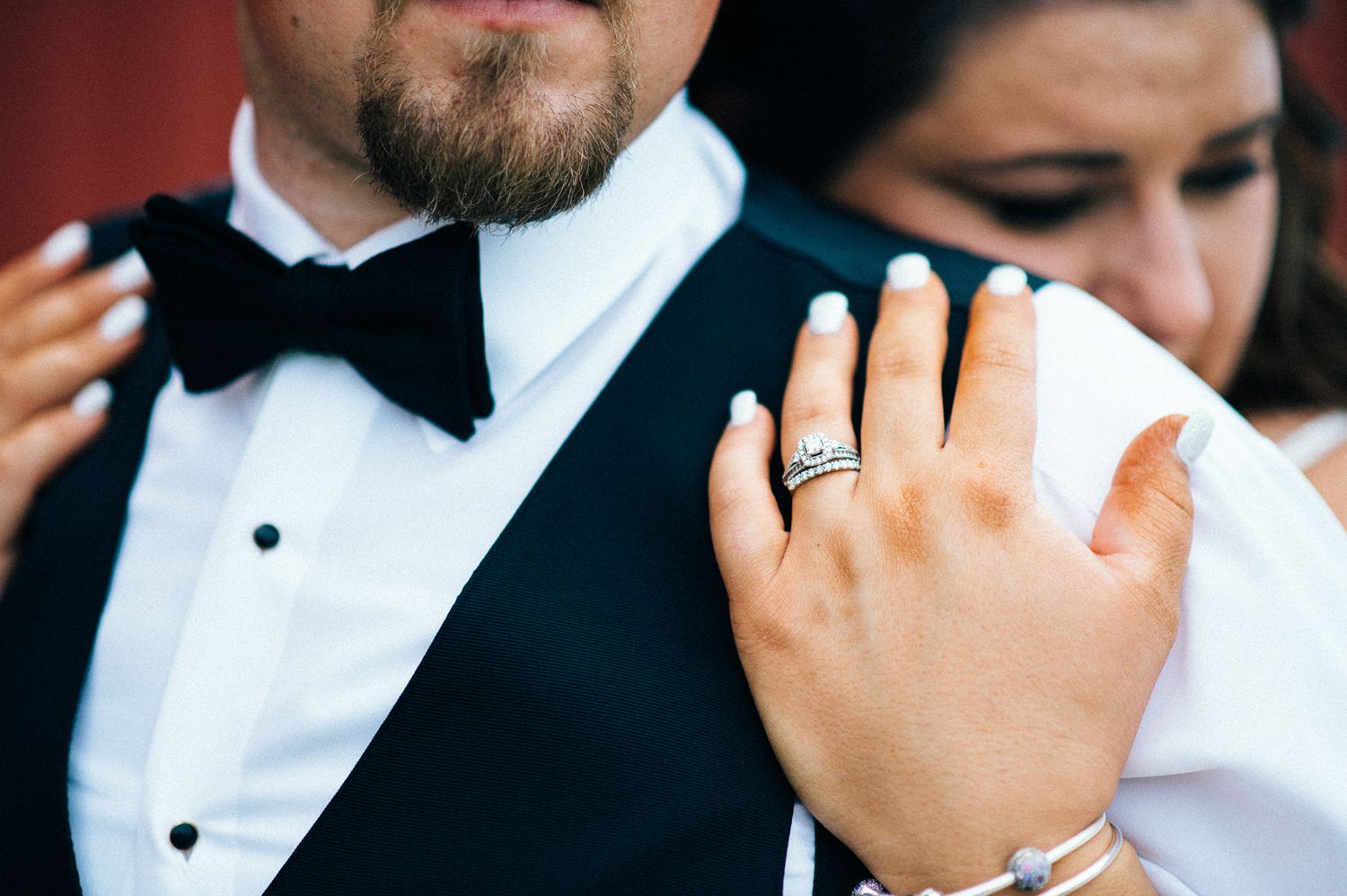 Detail shot of formal black bow tie and white tuxedo shirt at wedding.