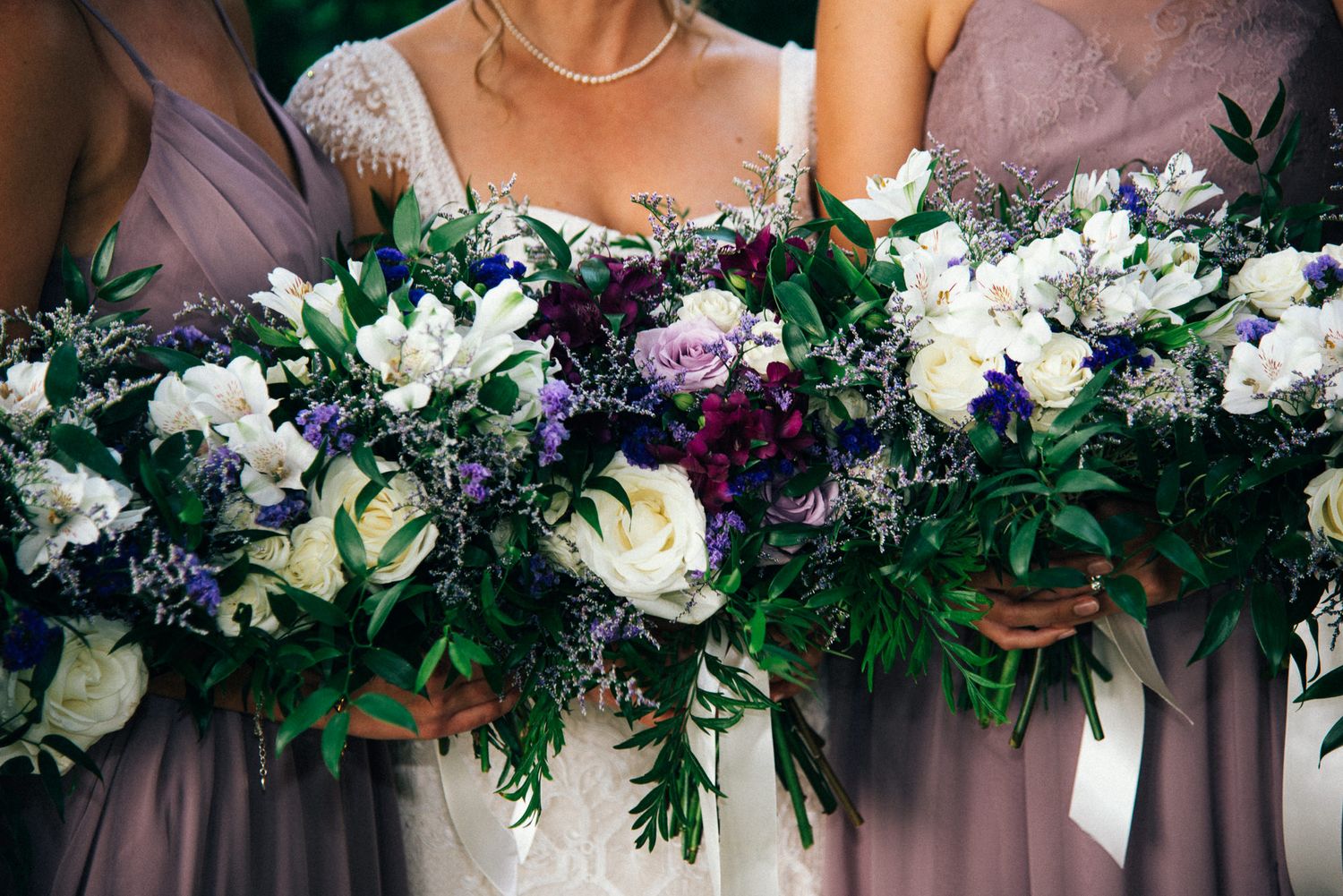 Elegant floral wedding arch decoration with white and purple blooms.