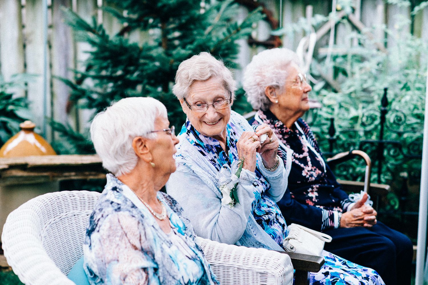 Elderly guests enjoying outdoor wedding reception celebrations.