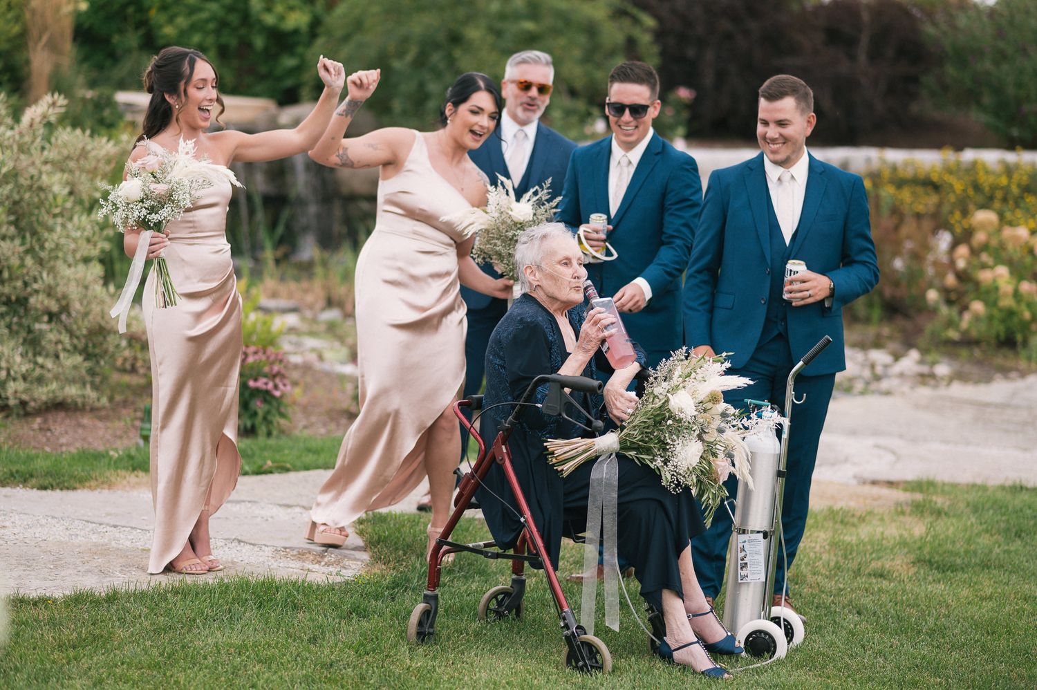 Wedding party plays soccer on grass lawn during casual outdoor photo session.