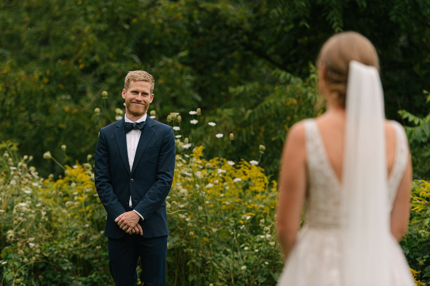 A wedding couple shares a special moment in a field of yellow wildflowers.