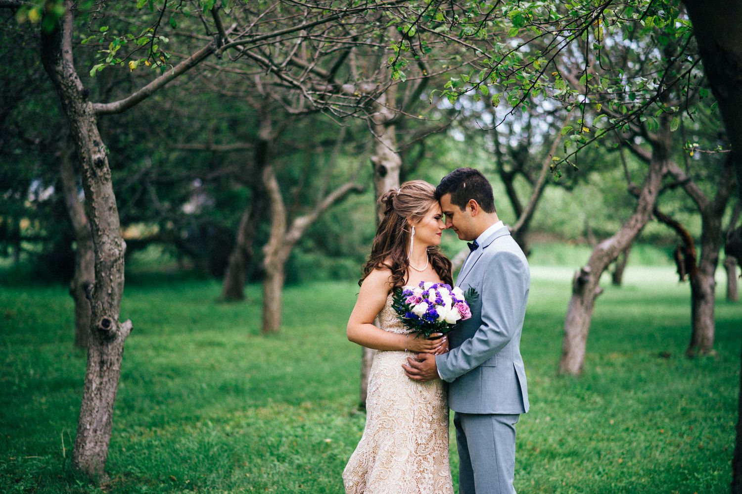 Couple shares intimate moment in an orchard garden during their wedding.