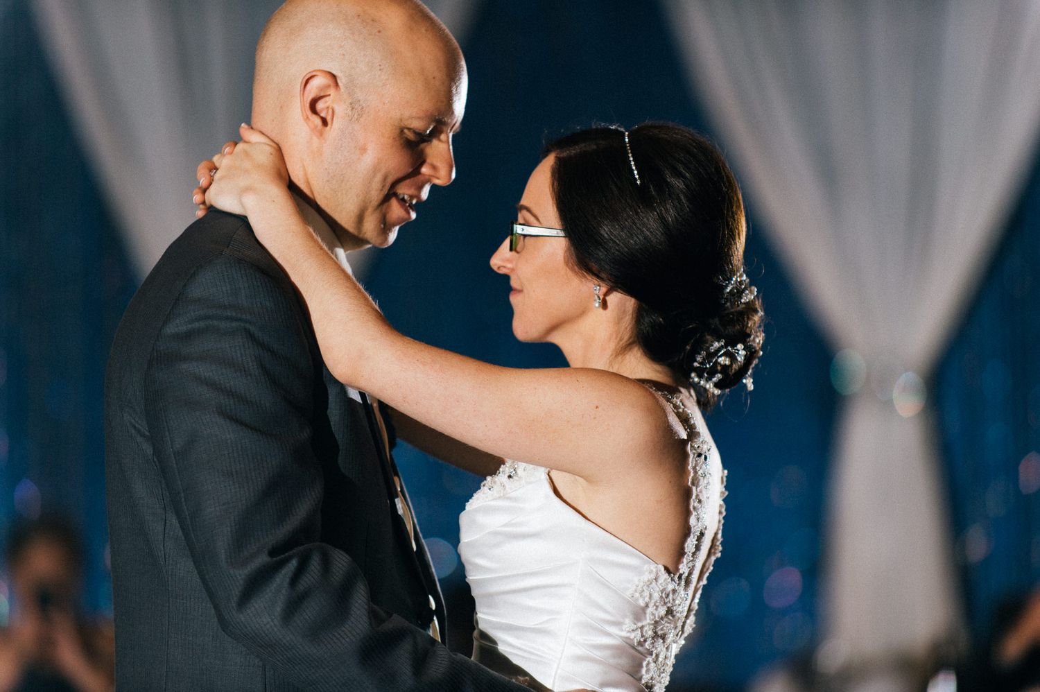 A romantic dance moment captured during a wedding reception with soft lighting.