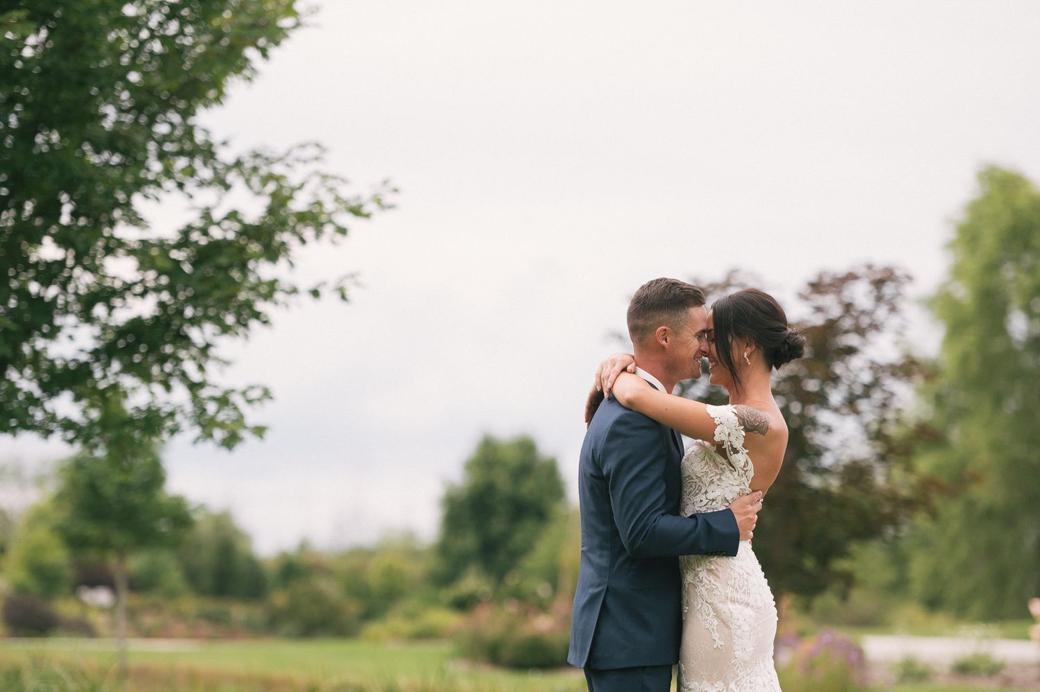Romantic outdoor wedding portraits captured in lush garden setting.