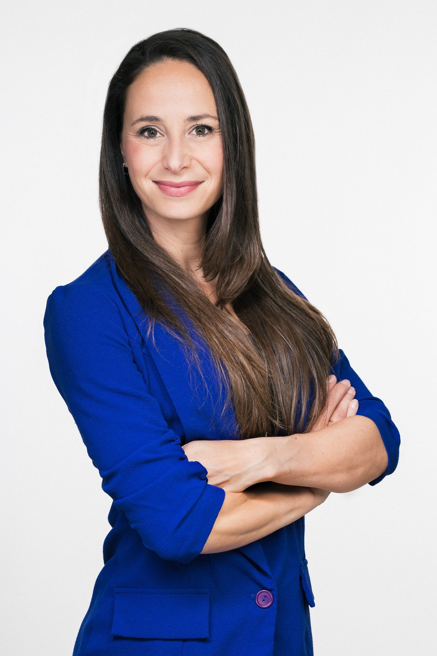 Professional studio portrait against white background featuring a person in a vibrant royal blue blazer.