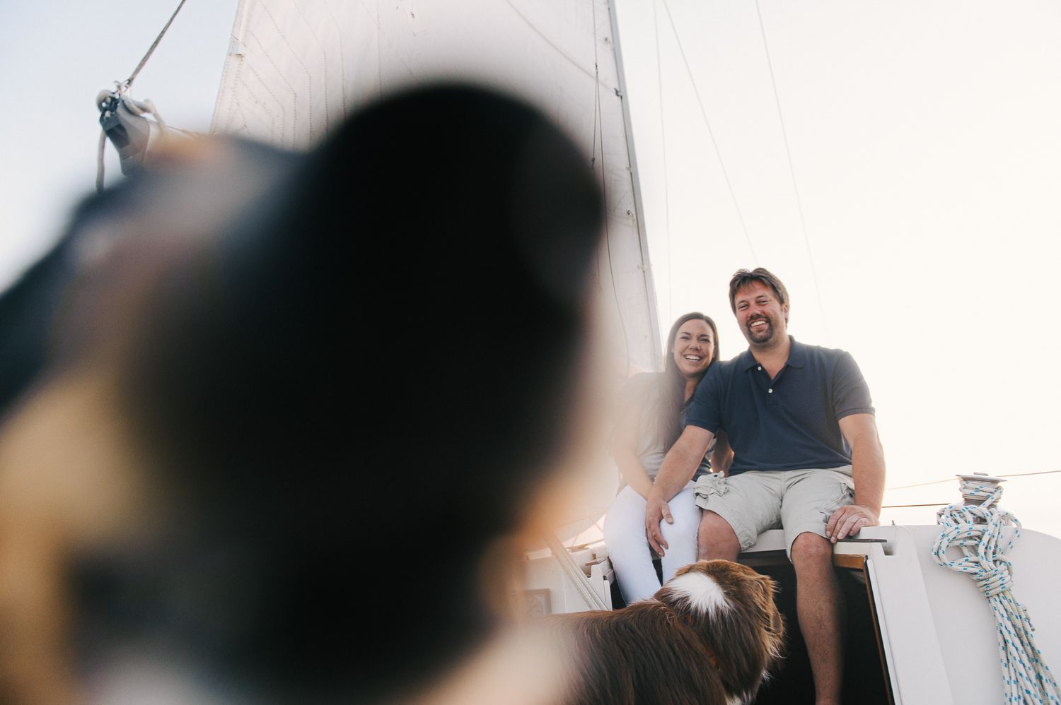Couple relaxing together on a sailboat during a sunny afternoon.